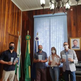 Pessoas segurando álcool em gel da Unicentro 