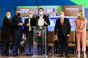 Governador do Paraná com outras autoridades em pé, posando para foto. 