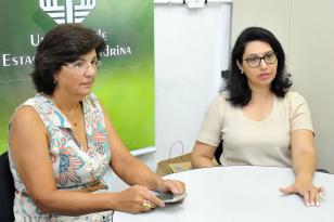 Professoras sentadas com mesa na frente