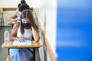 Alunos em sala de aula escrevendo 