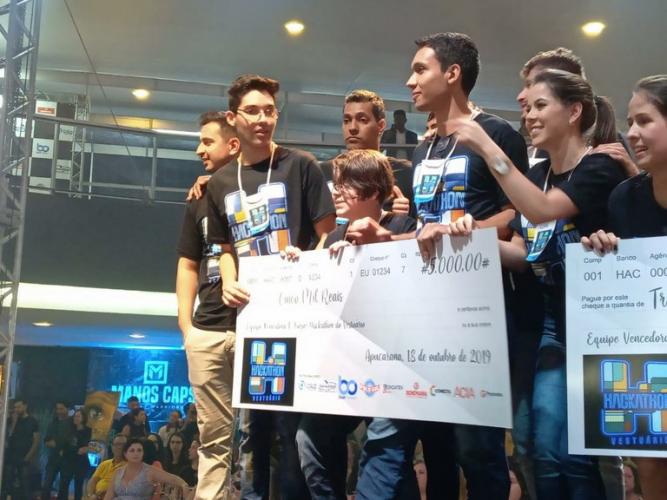 alunos da Unespar segurando o prêmio