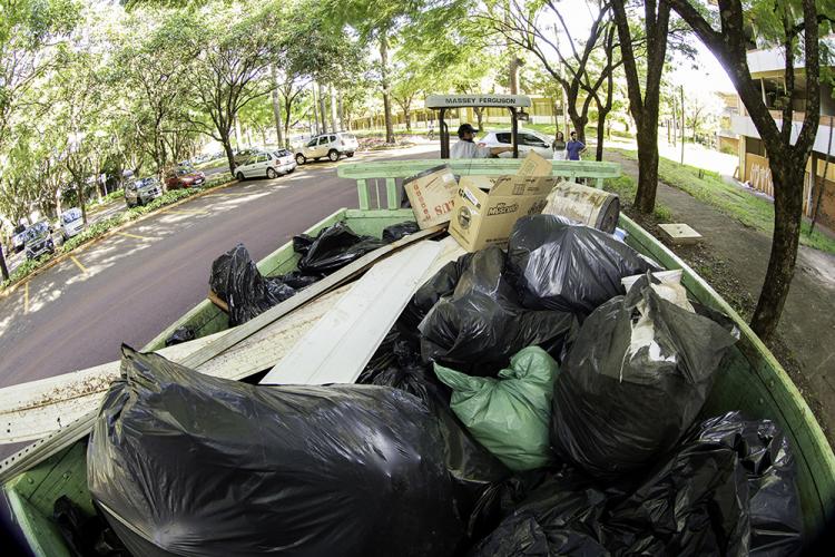 Lixo e entulho cobrem metade da carroceria do trator que ajudou na coleta