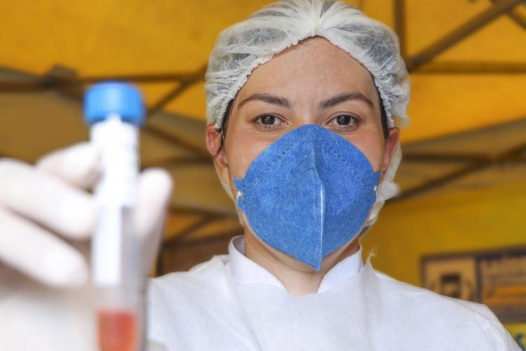 Mulher com amostra de sangue na mão