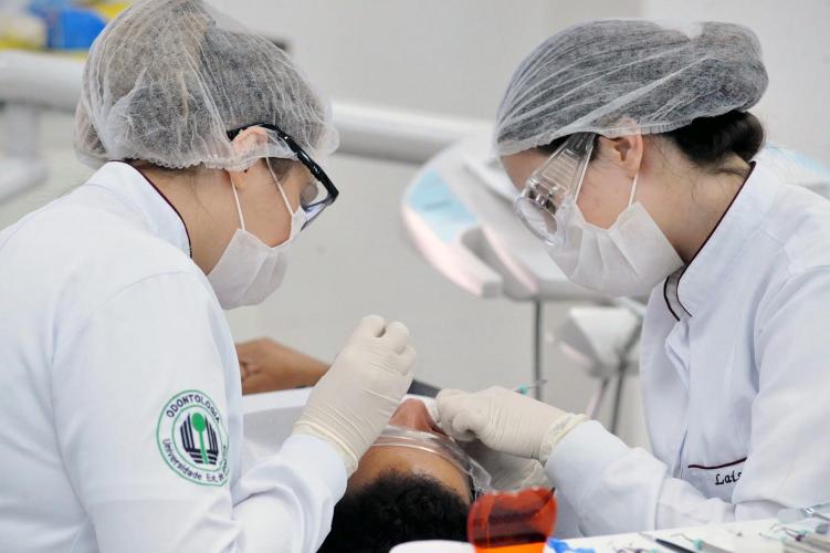 Estudantes de odontologia atendendo em clínica