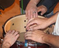 alunos do projeto manejam os instrumentos musicais